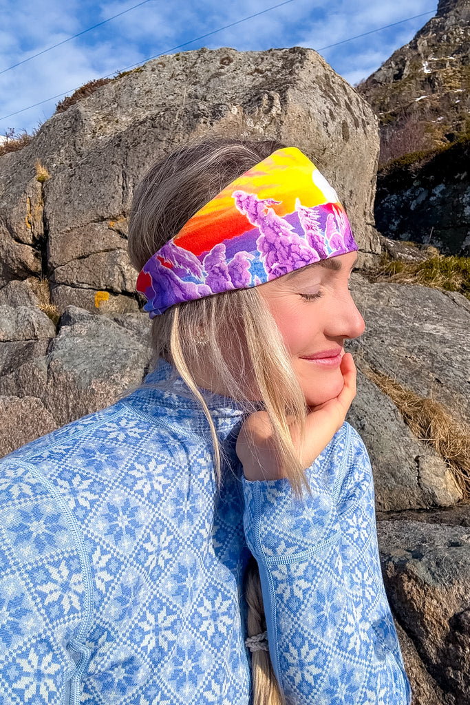 Side profile of a blond woman wearing The Snowy Path headband in front of rocks